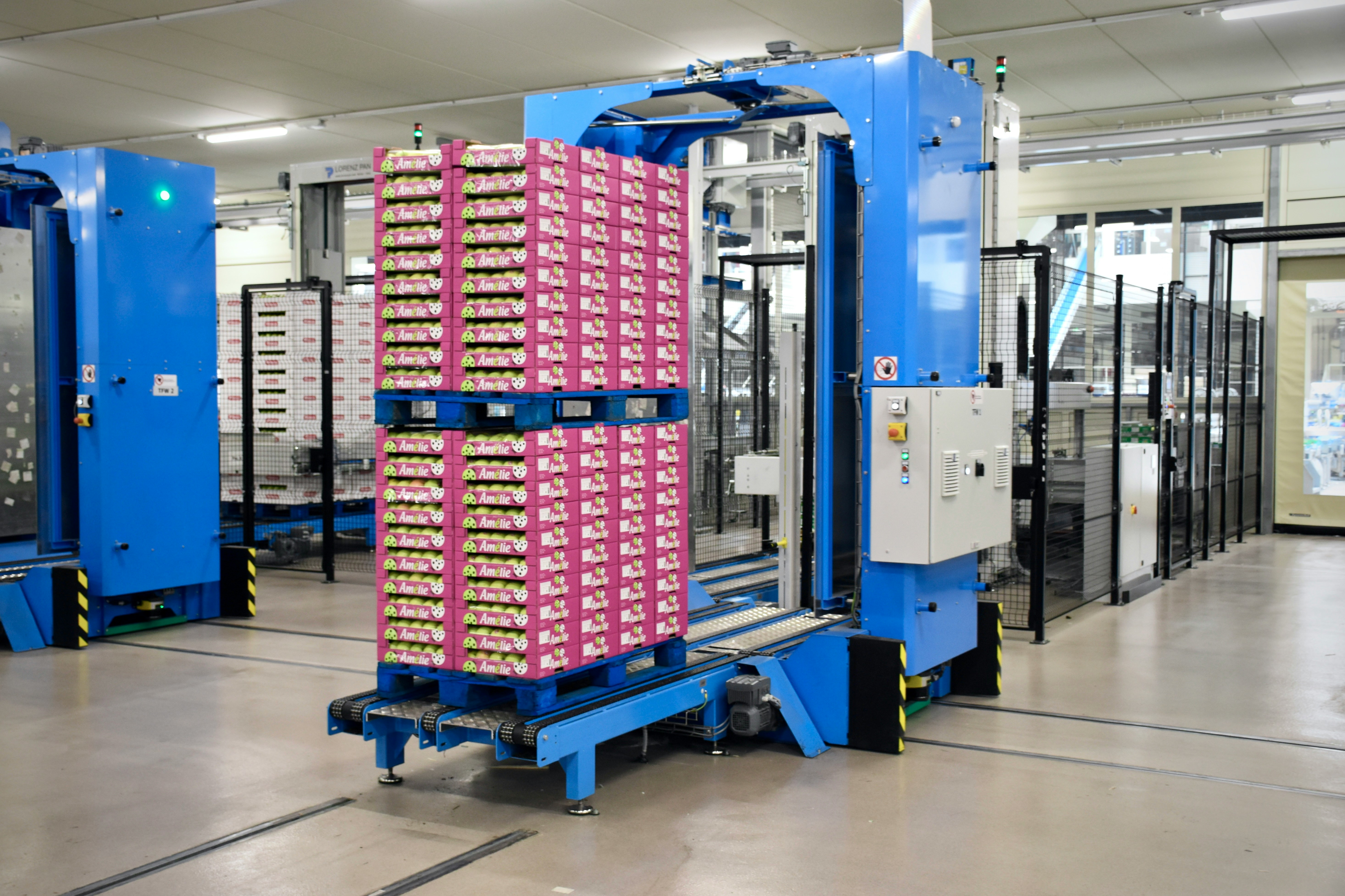 A picture of stacked fruit boxes on a machine